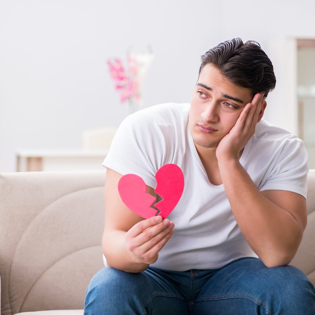 A man holds a broken while sitting on the floor alone with a stressed expression. Learn how body image therapy in California can offer support by searching for "dealing with body comments". Search for eating disorder therapist Orange County today.